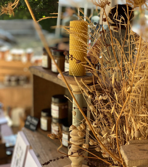 Bougie en cire d'abeille allumée dans un décor chaleureux et authentique.