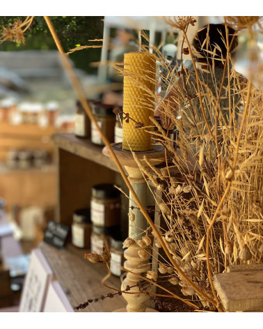 Bougie en cire d'abeille allumée dans un décor chaleureux et authentique.