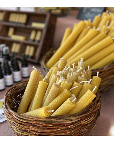 Bougies en cire d'abeille disposées dans un panier pour une ambiance rustique.