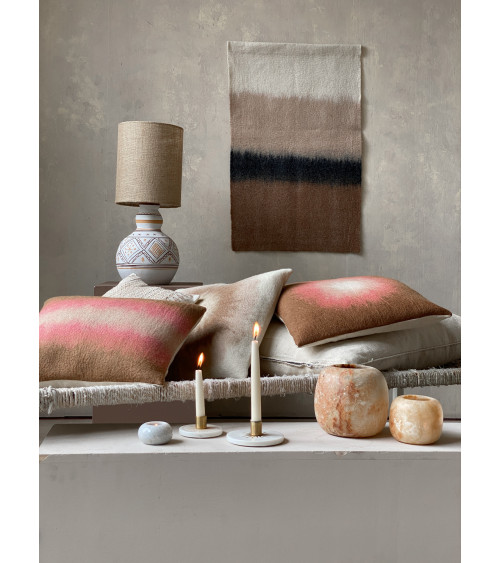 Ambiance salon avec coussins et bougeoirs en marbre, pour un style élégant et accueillant.