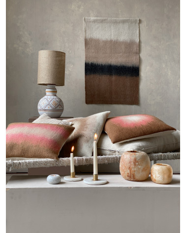 Ambiance salon avec coussins et bougeoirs en marbre, pour un style élégant et accueillant.