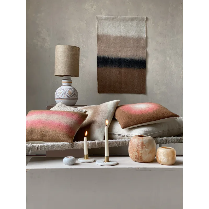 Scène de salon, le bougeoir en marbre L accompagne des coussins et objets décoratifs, créant une atmosphère accueillante.
