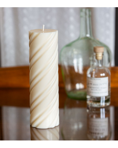 Bougie naturelle et artisanale en cire de colza Ø 7 cm H 23 cm sur une table en verre