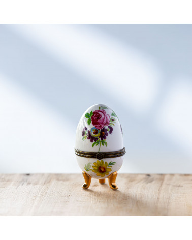 Bougie Œuf de type Fabergé avec motif floral et rose.