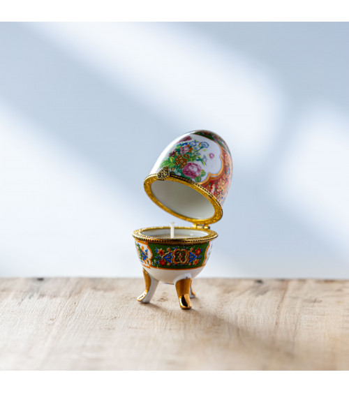 Bougie parfumée dans un œuf de porcelaine ouvert, orné de motifs floraux.