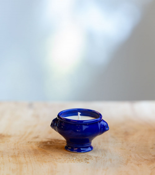 Bougie parfumée dans une cocotte en céramique bleu foncé.