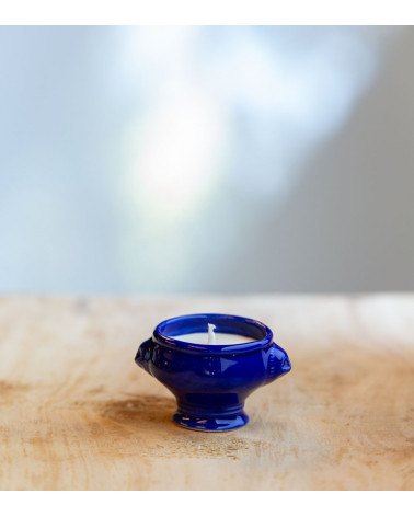 Bougie parfumée dans une cocotte en céramique bleu foncé.
