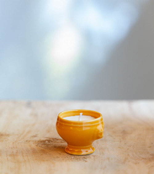 Bougie dans une cocotte jaune, ajoutant une touche colorée et élégante.