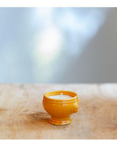 Bougie dans une cocotte jaune, ajoutant une touche colorée et élégante.