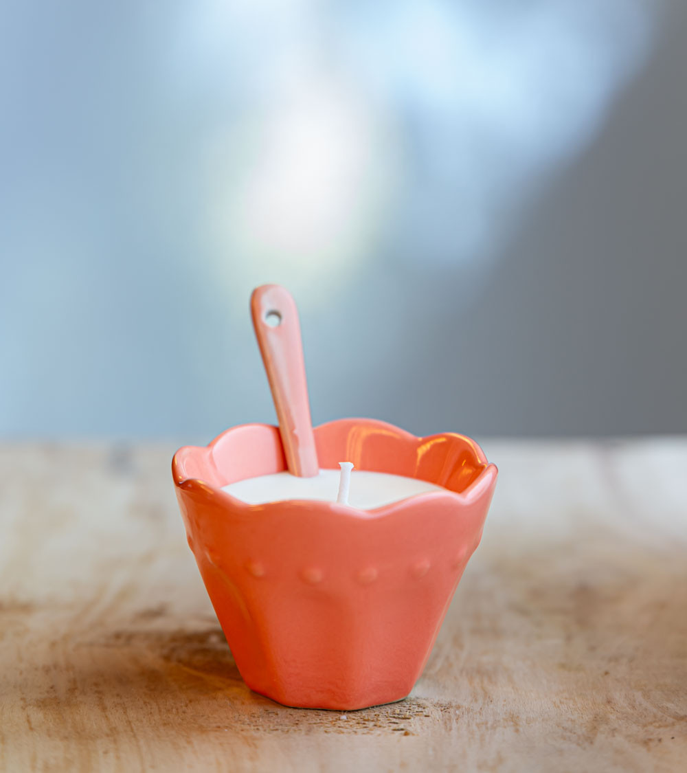 Ramequin rose avec bougie et cuillère assortie.
