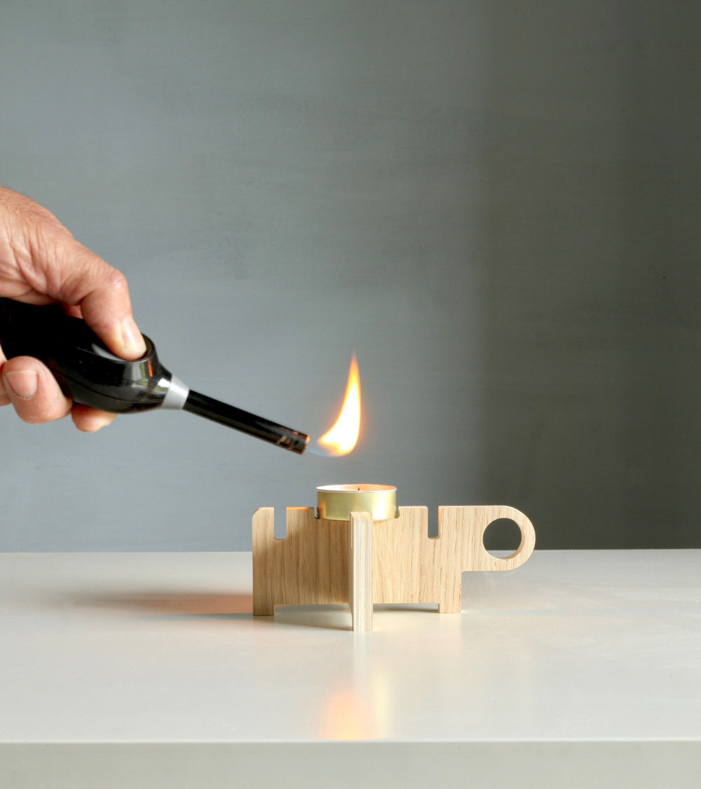 Allumage de la bougie sur la base en bois du bougeoir.