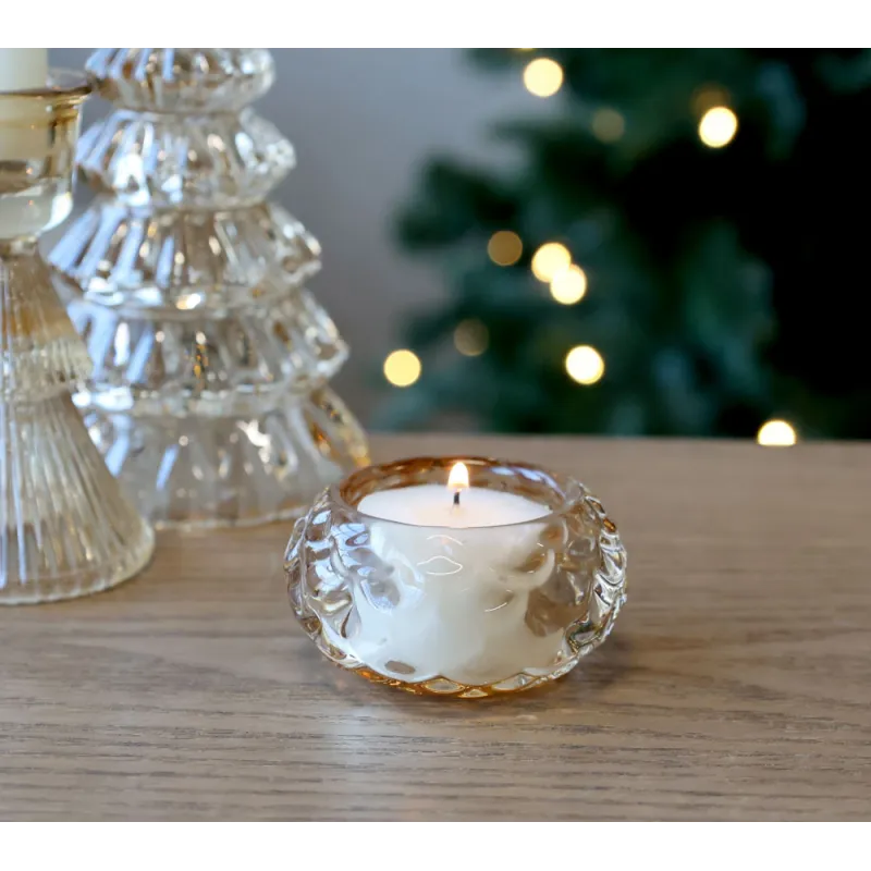 Photophore en verre ambré allumé, ambiance festive.