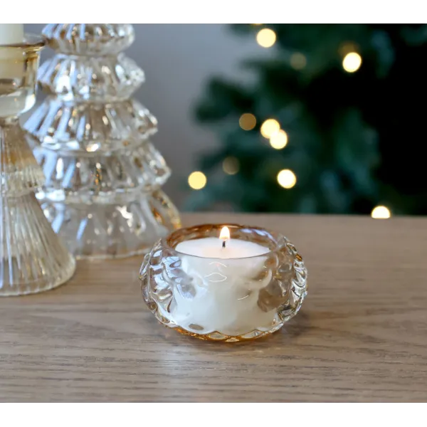 Photophore en verre ambré allumé, ambiance festive.